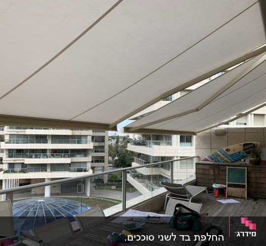 סוככים לבנים נפתחים מעל מרפסת עם ריהוט חוץ